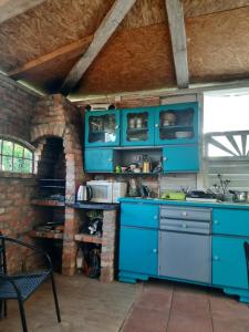 a kitchen with blue cabinets and a brick wall at Toporzanka in Toporzysko