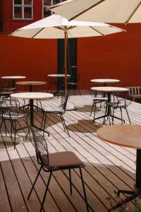 eine Gruppe von Tischen und Stühlen mit Sonnenschirmen auf einer Terrasse in der Unterkunft Audo Copenhagen in Kopenhagen