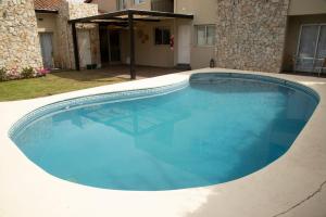 a large swimming pool with blue water at Rozas Apart in Ezeiza