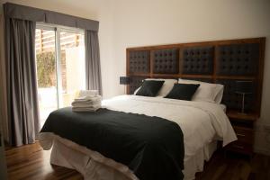 a bedroom with a large bed and a window at Rozas Apart in Ezeiza +21 photos
