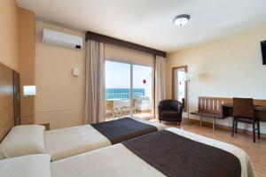 a hotel room with two beds and a view of the ocean at Rincón Sol in Rincón de la Victoria