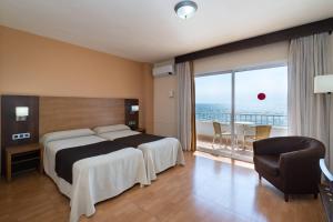 a hotel room with a bed and a balcony at Rincón Sol in Rincón de la Victoria