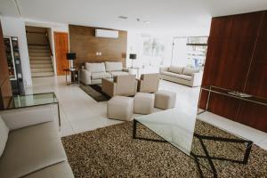 sala de estar con muebles blancos y mesa de cristal en Mar de Canasvieiras Hotel e Eventos en Florianópolis