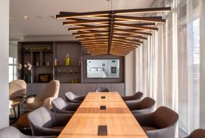 a conference room with a wooden table and chairs at elaya hotel kevelaer in Kevelaer