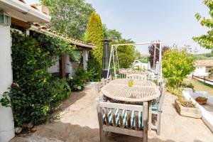 een houten tafel en stoelen op een patio bij Cortijo mirasol in Santa Cruz de Comercio