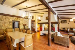 a dining room and living room with a table and chairs at Cortijo mirasol in Santa Cruz de Comercio
