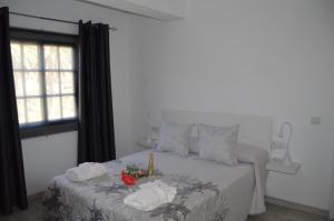 Un dormitorio blanco con una cama con toallas. en Casa Rural Guadá, en Valle Gran Rey