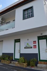 een wit gebouw met groene deuren en potplanten bij Casa Rural Guadá in Valle Gran Rey