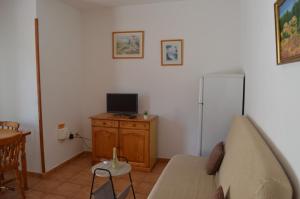 a living room with a couch and a television at Casa Rural Guadá in Valle Gran Rey