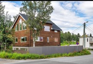 una casa de madera al lado de una carretera en Unique Apartments Tromsø, en Tromsø