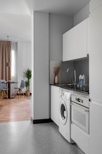 a white kitchen with a washing machine in it at Bob W Madrid Atocha in Madrid