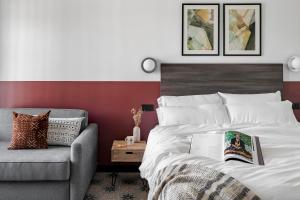 a bedroom with a bed and a couch with a book on it at Bob W Madrid Atocha in Madrid +41 photos