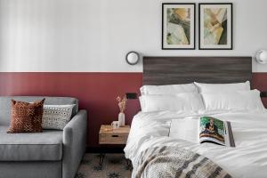 Un dormitorio con una cama y un sofá con un libro. en Bob W Arte, en Madrid