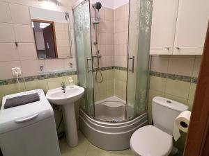 een badkamer met een douche, een toilet en een wastafel bij Labo Apartment Metro Pole Mokotowskie in Warschau