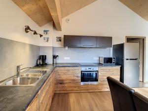 uma cozinha com armários de madeira e electrodomésticos de aço inoxidável em Appartement La Toussuire, 4 pièces, 10 personnes - FR-1-417-38 em La Toussuire