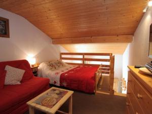 ラ・トゥッスイールにあるStudio La Toussuire, 1 pièce, 4 personnes - FR-1-417-53のベッドルーム(赤いベッド1台、赤いソファ付)