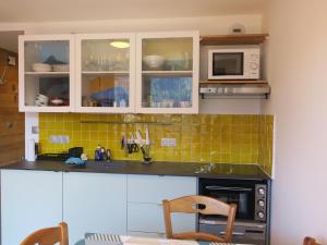 uma cozinha com armários brancos, um fogão e micro-ondas em Appartement Châtel, 2 pièces, 4 personnes - FR-1-198-218 em Châtel