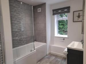 a bathroom with a tub and a toilet and a sink at Fairwater Head in Axminster