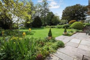 a garden with a stone pathway and flowers at Hillside House - beautiful 16th century house with Wifi, Parking, games room, Netflix in Oakhill