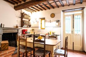 een keuken met een tafel met stoelen en een open haard bij Il Mulino di Candalla in Camaiore
