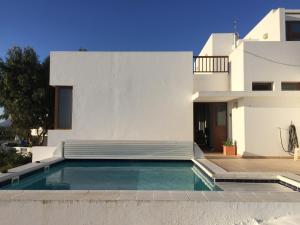 a swimming pool in front of a white house at El Olivo Beautiful Rural location 3 bed villa in Conil