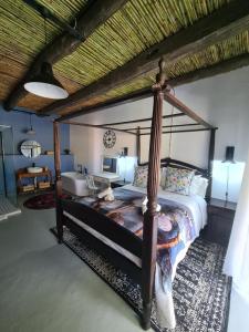 een slaapkamer met een hemelbed in een kamer bij Harmonie Farm Cottages in Montagu