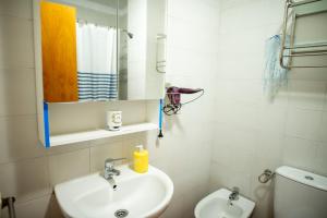 a bathroom with a sink and a mirror and a toilet at Casa Sami in Playa de las Americas