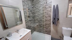 a bathroom with a sink and a toilet and a shower at Lovely Apartment with Side Sea View in St Paul's Bay +8 photos