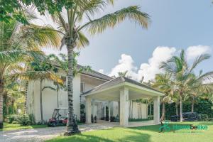 uma casa com palmeiras em frente em Majestic Golf View 4BR Villa at Punta Cana Resort em Punta Cana