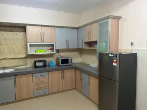 eine Küche mit einem Kühlschrank und einer Mikrowelle in der Unterkunft D’Lestari Homestay in Seri Kembangan