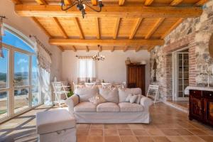 sala de estar con sofá blanco y pared de piedra en Tenute Shardana Luxury Farmhouse with SPA, Sauna, Heated Swimming Pool en Mores