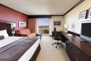 a hotel room with a bed and a desk and a television at Crowne Plaza Albuquerque by IHG in Albuquerque
