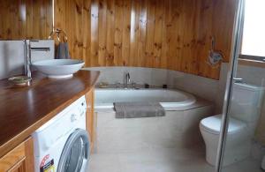 a bathroom with a tub and a toilet and a sink at The Boomerangs at Johanna on the Great Ocean Road in Johanna