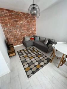 a living room with a couch and a table at Central Apartments Ogrody 3 & Parking in Gdańsk