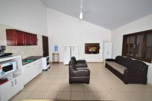 uma sala de estar com dois sofás e uma cozinha em Casa Canela, 450 mts da Praia de Mariscal. em Bombinhas