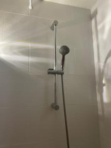 a shower with a shower head in a bathroom at Appartement de deux chambres au calme in Nozay