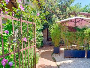 un jardín con una valla de madera y flores en El Patio de Valentina, en Navacerrada