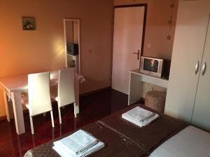 a small room with a table and a television at Apartments and Rooms Sinka in Biograd na Moru