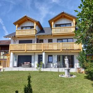 una casa grande con una terraza y una estatua en Haus Tobias, en Bad Füssing