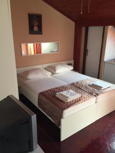 a bedroom with a large bed with a tv at Apartments and Rooms Sinka in Biograd na Moru