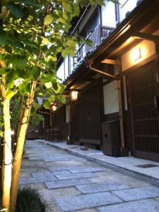 um edifício com uma árvore em frente a uma passagem em Imakumano Terrace - Mokubei An 木米庵 em Quioto
