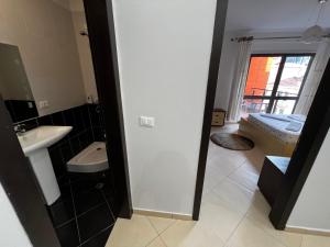 een badkamer met een wastafel en een bed in een kamer bij Grande Veranda 2 in Tirana
