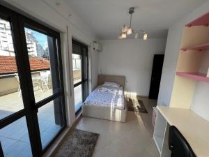 une chambre avec un lit dans une pièce avec une fenêtre dans l'établissement Grande Veranda 2, à Tirana