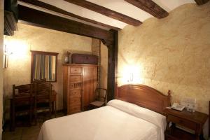 1 dormitorio con 1 cama, 1 mesa y 1 silla en Hotel Rural Bidean, en Puente la Reina