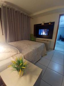 um quarto de hotel com uma cama e uma televisão em Apartamento Jussara Freitas 2 quartos no Recife