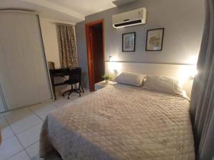 a bedroom with a large bed and a desk at Apartamento Jussara Freitas 2 quartos in Recife