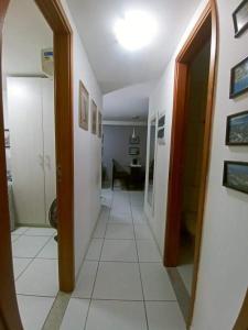 um corredor com um espelho e um quarto com uma mesa em Apartamento Jussara Freitas 2 quartos no Recife