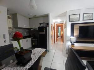 uma cozinha com um frigorífico preto e uma mesa em Apartamento Jussara Freitas 2 quartos no Recife