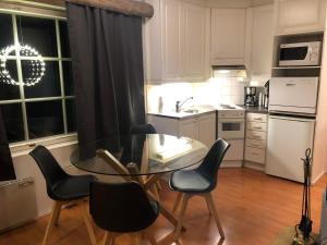 a kitchen with a glass table and black chairs at Rukankieppi in Ruka