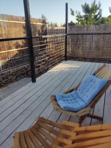 a chair with a blue cushion on a deck at Wooden Zimmer El-Rom in El-Rom